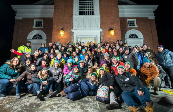 A group of people outdoors at night smiling at the camera before an all-night fundraising event.